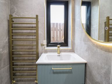 A bathroom with a sink and a towel radiator at Pistyll Ddu in Brynsiencyn near Llanfairpwllgwyngyll
