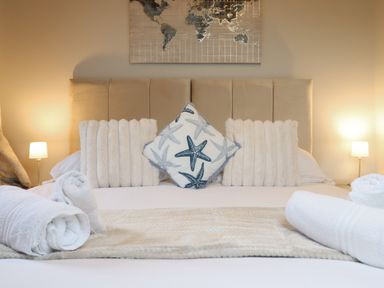 A bed with pillows and lamps at Pistyll Ddu in Brynsiencyn near Llanfairpwllgwyngyll