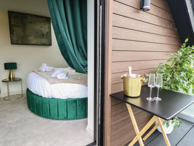 A bedroom with a round bed and access to a balcony at Pistyll Ddu Brynsiencyn near Llanfairpwllgwyngyll