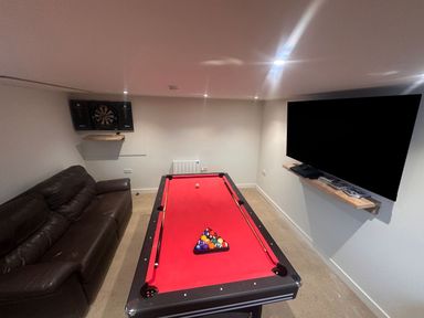A game room with a pool table and dartboard at Pistyll Ddu in Llanfairpwllgwyngyll