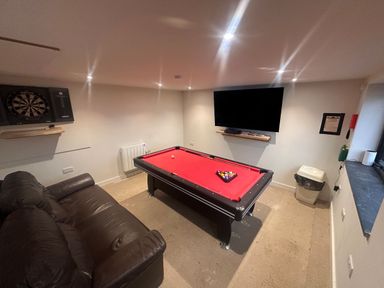 A game room with a pool table and dartboard at Pistyll Ddu in Llanfairpwllgwyngyll