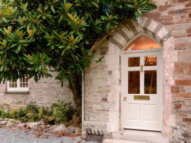 An entrance door with a tree beside it at Ladye Park in Liskeard