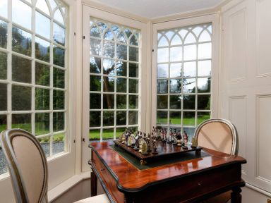 A snug with windows and a table with chess pieces at Ladye Park in Liskeard