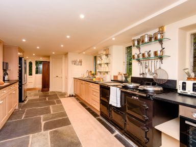 A kitchen with a cooking stove and refrigerator at Ladye Park in Liskeard