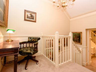 A hallway with a writing desk and chair at Ladye Park in Liskeard