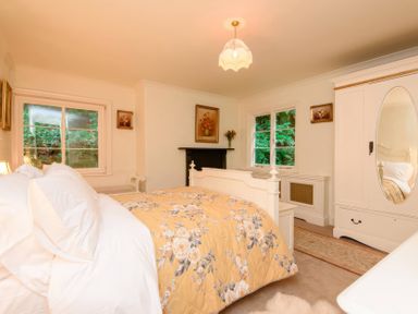 A bedroom with a bed and a wardrobe at Ladye Park in Liskeard