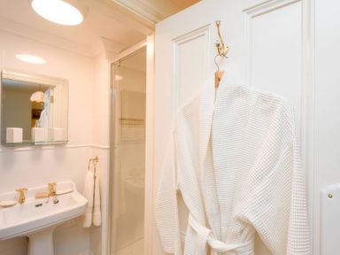 A bathroom with a sink, mirror, and shower at Ladye Park in Liskeard