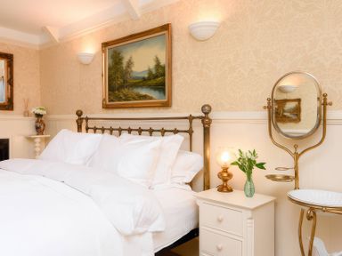 A bedroom with a bed and nightstand at Ladye Park in Liskeard