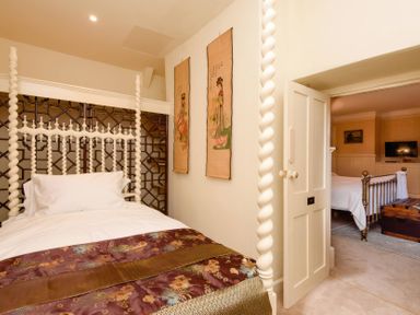 A bedroom with a four-poster bed and wall art at Ladye Park in Liskeard