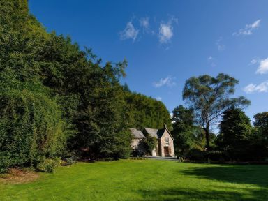 A house in a garden with trees and grass at Ladye Park in Liskeard