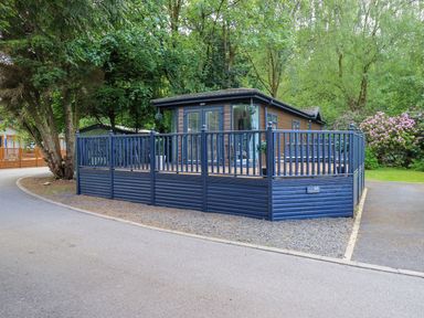 A house with a deck and fence in an outdoor area at Evermore Lodge, 48 Calgarth Park, White Cross Bay, Windermere