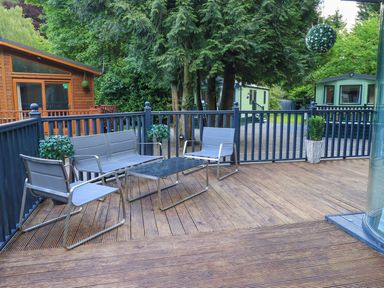 An outdoor seating area with chairs and a table at Evermore Lodge 48 Calgarth Park, White Cross Bay, Windermere