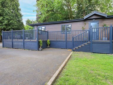 An outdoor view of a building with a deck and steps at Evermore Lodge, 48 Calgarth Park, White Cross Bay, Windermere