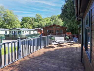 An outdoor area with furniture and greenery at Evermore Lodge, 48 Calgarth Park, White Cross Bay, Windermere