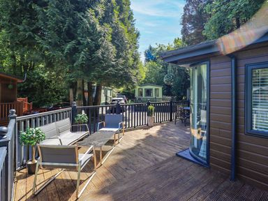 An outdoor deck with a table and chairs at Evermore Lodge, 48 Calgarth Park, White Cross Bay, Windermere