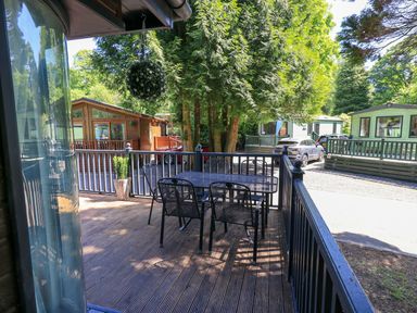 An outdoor deck area with a table and chairs at Evermore Lodge, 48 Calgarth Park, White Cross Bay, Windermere
