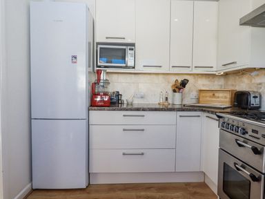 A kitchen with appliances and storage at Woodbury in Teignmouth