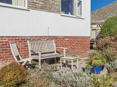 A garden with a bench and table at Woodbury Teignmouth