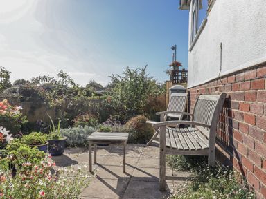 A garden with a table and benches at Woodbury in Teignmouth