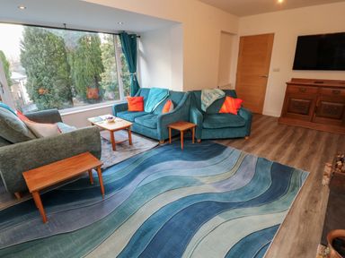 A living room with sofa, armchair and coffee table at Westerlodge Threlkeld near Keswick