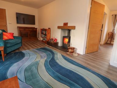 A living room with a sofa and television at Westerlodge Threlkeld near Keswick