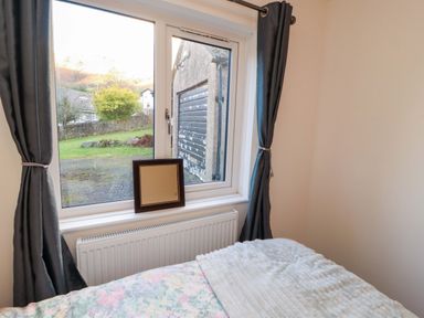 A bedroom with a window and curtains at Westerlodge in Threlkeld near Keswick