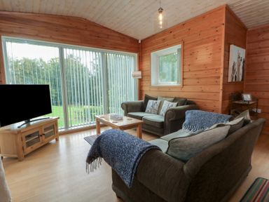 A living room with a sofa and coffee table at Woodlands View in Leek