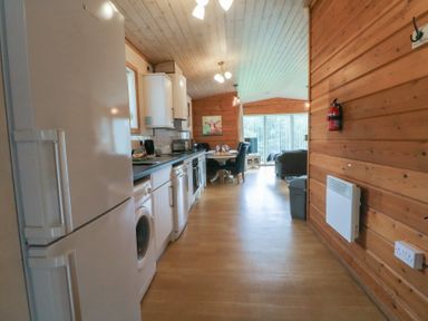 A kitchen with appliances and dining area at Woodlands View in Leek