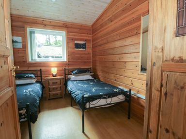 A bedroom with two beds and a window at Woodlands View in Leek