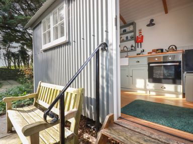 A kitchen with a door and window leading to the outside at Hillbre Shepherd Hut, Padstow