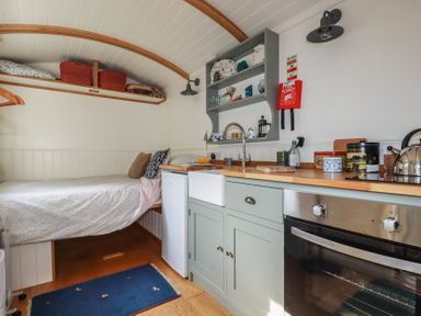A studio with a bed and kitchen area at Hillbre Shepherd Hut in Padstow