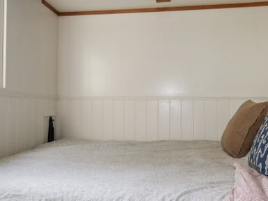 A bedroom with a bed and pillows at Hillbre Shepherd Hut in Padstow