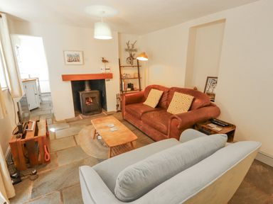 A living room with a sofa and a fireplace at Rock Cottage in Milnthorpe