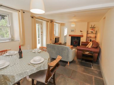 A dining room with a table and chairs at Rock Cottage in Milnthorpe