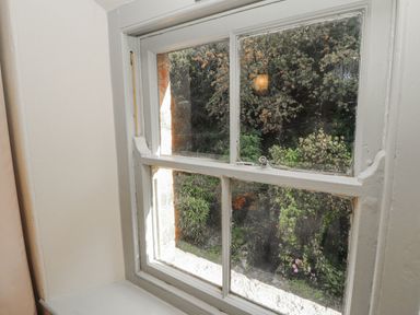 A window with a view of outdoor plants at Rock Cottage Milnthorpe