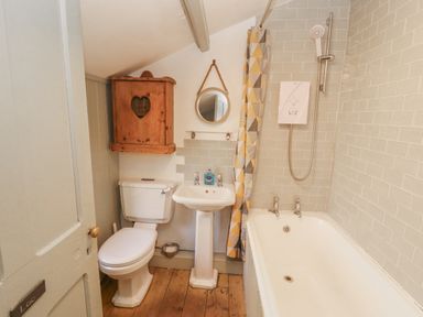 A bathroom with a bathtub, sink, and toilet at Rock Cottage in Milnthorpe