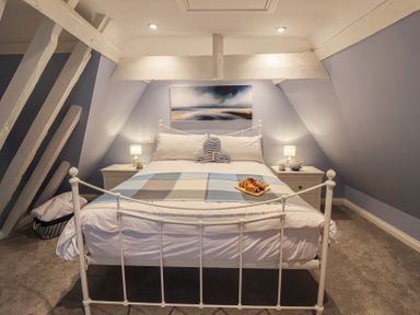 A bedroom with a bed and bedside tables at The Nutshell in Aldeburgh