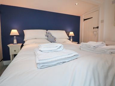 A bedroom with a bed and bedside lamps at The Nutshell in Aldeburgh