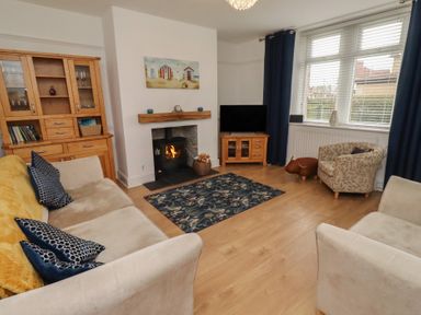 A living room with a sofa and armchair at 23 Northumbria Terrace Amble
