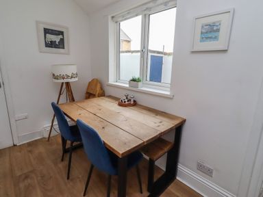 A dining room with a table and chairs at 23 Northumbria Terrace Amble