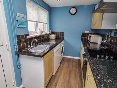 A kitchen with a sink and appliances at 23 Northumbria Terrace Amble