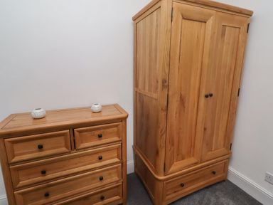 A chest of drawers and wardrobe in a bedroom at 23 Northumbria Terrace in Amble