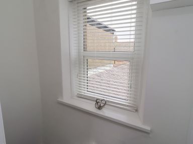 A window with blinds and a decorative object on the ledge at 23 Northumbria Terrace Amble