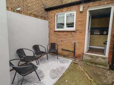 A garden with chairs and a doorway at 23 Northumbria Terrace Amble