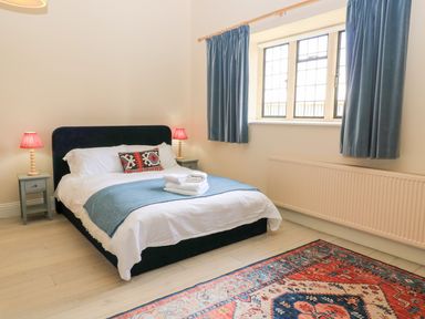 A bedroom with a bed and two lamps at Woodcock Studio in Andoversford near Cheltenham