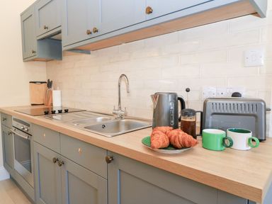 A kitchen featuring a sink, cooking hob, oven, and kitchenware at Swallow Studio in Andoversford near Cheltenham
