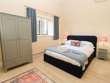 A bedroom with a bed and wardrobe at Swallow Studio in Andoversford near Cheltenham