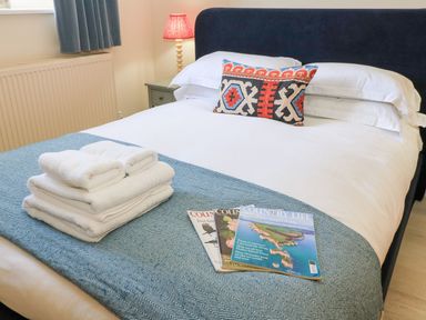 A bedroom with a bed and towels on the covers at Swallow Studio in Andoversford near Cheltenham