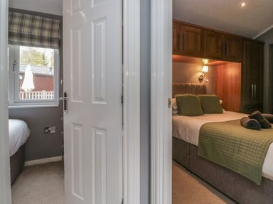 A bedroom with a door and window view at 32 Grasmere, White Cross Bay near Windermere