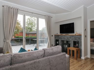 A living room with a sofa and television at 7 Lake View in Windermere